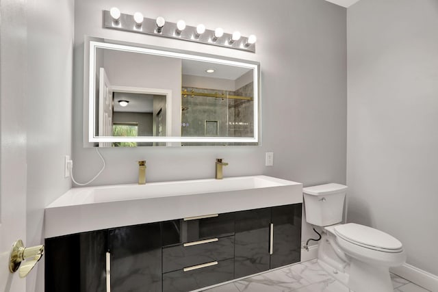 bathroom featuring a shower with door, vanity, and toilet