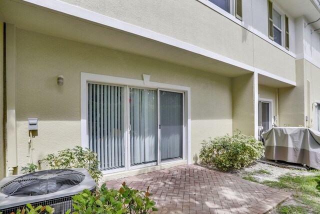 entrance to property featuring cooling unit and a patio area