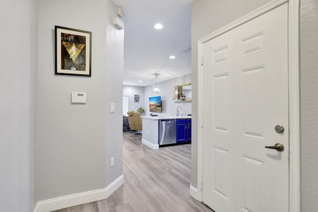 corridor with sink and light hardwood / wood-style flooring