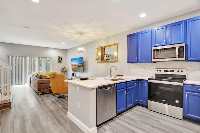 kitchen with blue cabinetry, sink, appliances with stainless steel finishes, and tasteful backsplash