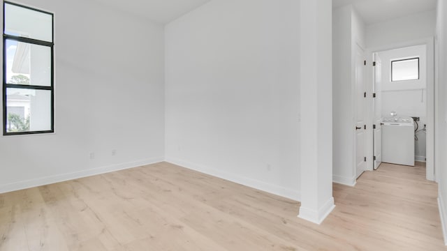 empty room featuring washer / clothes dryer and light hardwood / wood-style flooring