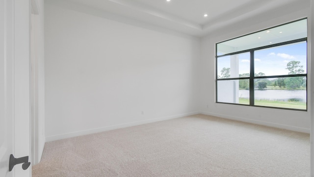 carpeted empty room featuring a water view