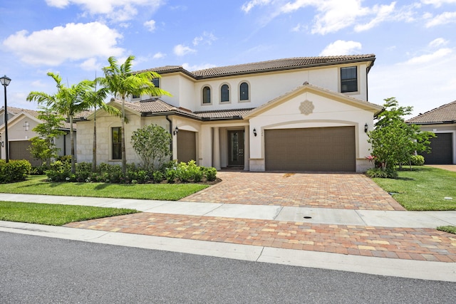 mediterranean / spanish-style home featuring a front lawn and a garage