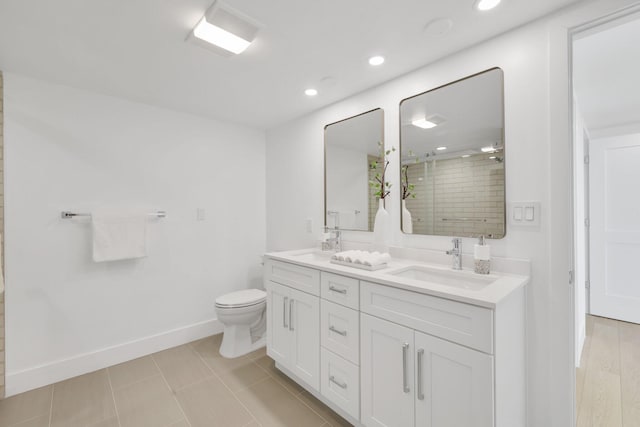 bathroom featuring vanity, a shower with door, and toilet