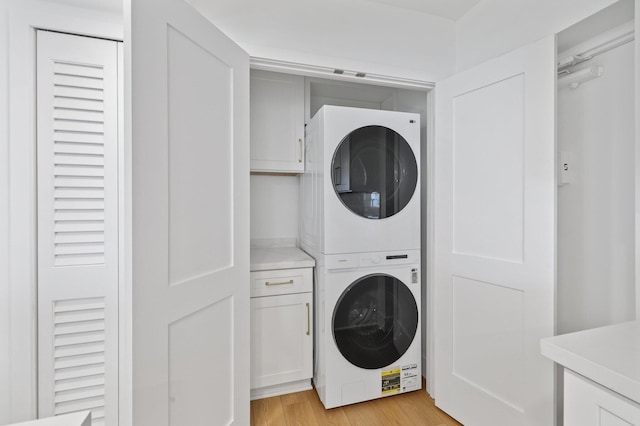 washroom featuring stacked washer and dryer and light wood-type flooring