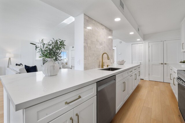 kitchen with white cabinets, dishwasher, light hardwood / wood-style floors, decorative backsplash, and sink