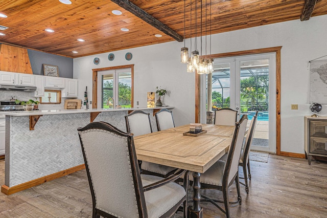 dining room featuring french doors, light wood-type flooring, beamed ceiling, and wooden ceiling