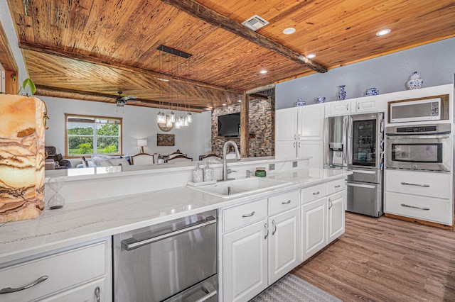 kitchen featuring wood ceiling, appliances with stainless steel finishes, beamed ceiling, and white cabinetry