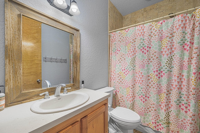 bathroom featuring a textured ceiling, toilet, and vanity