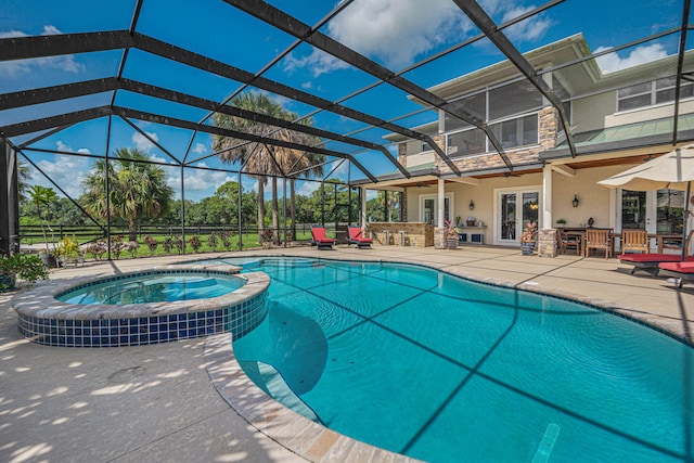 view of pool with exterior bar, a patio area, glass enclosure, and an in ground hot tub