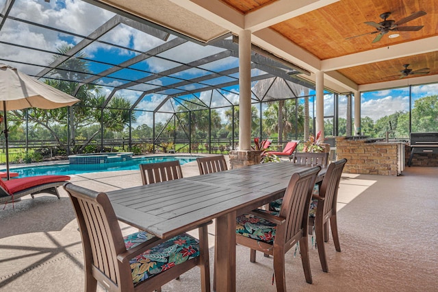 exterior space featuring ceiling fan, exterior bar, glass enclosure, and area for grilling