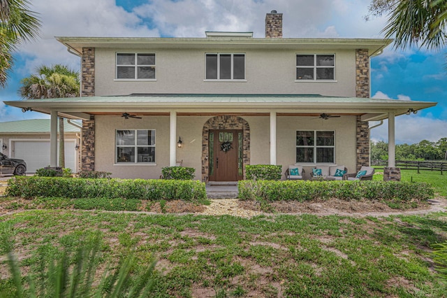 front facade featuring ceiling fan, a front yard, and a porch