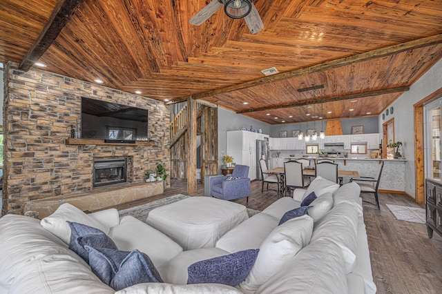 living room featuring ceiling fan, hardwood / wood-style floors, wood ceiling, and a fireplace