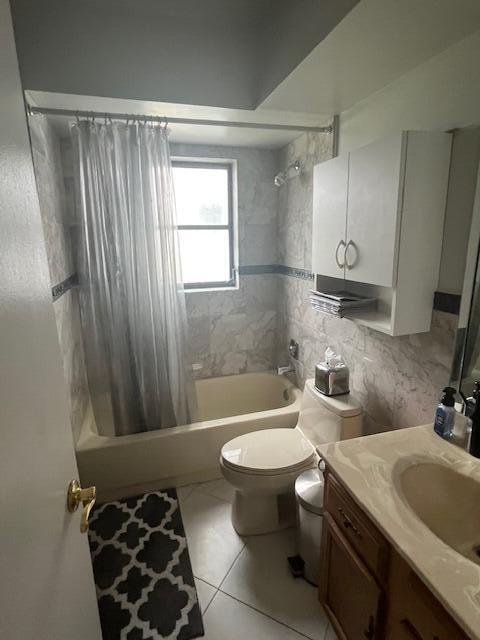 full bathroom featuring vanity, tile patterned floors, toilet, and shower / bath combo