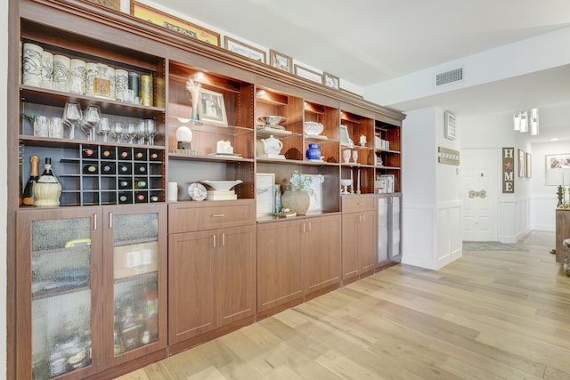 bar with light hardwood / wood-style flooring