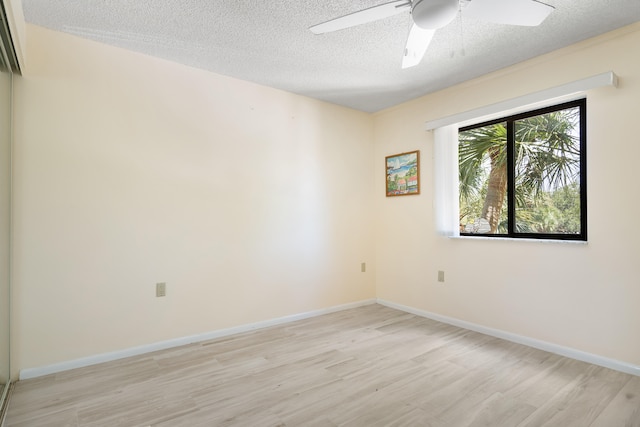 spare room with ceiling fan, light hardwood / wood-style floors, and a textured ceiling