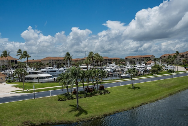 surrounding community with a water view and a yard