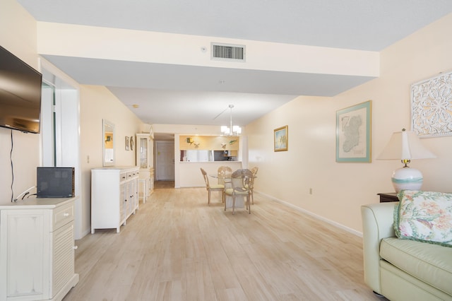 living room featuring light hardwood / wood-style flooring and an inviting chandelier