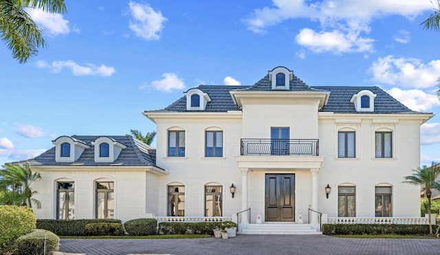 french provincial home featuring a balcony