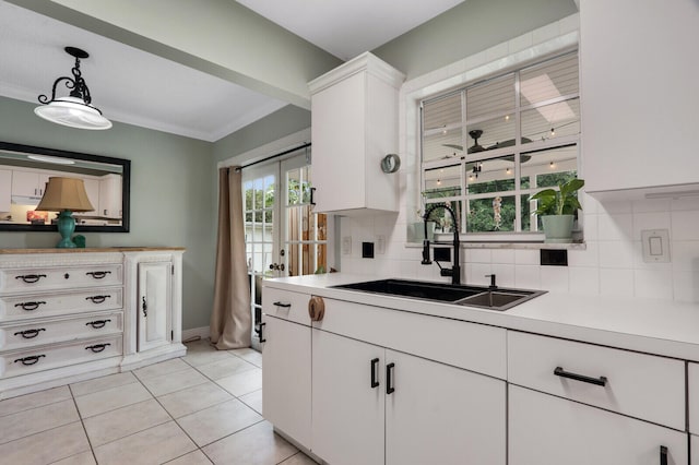 kitchen with sink, hanging light fixtures, decorative backsplash, light tile patterned flooring, and white cabinetry