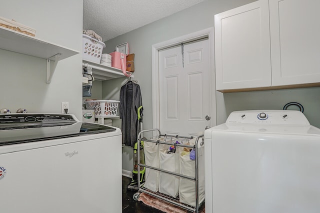 washroom with cabinets, a textured ceiling, and washer and clothes dryer