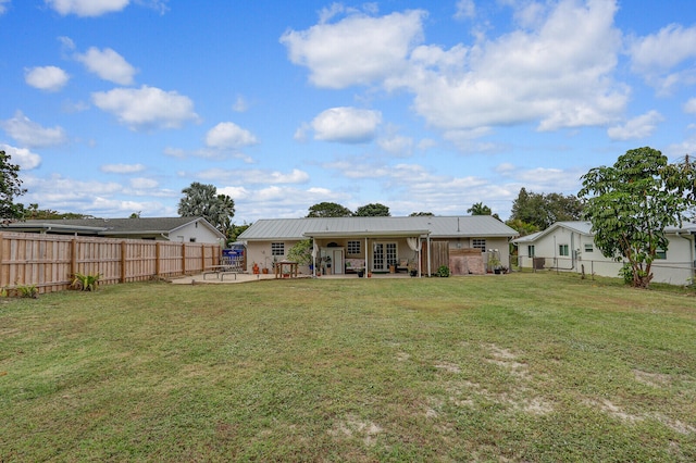 back of house featuring a lawn and a patio