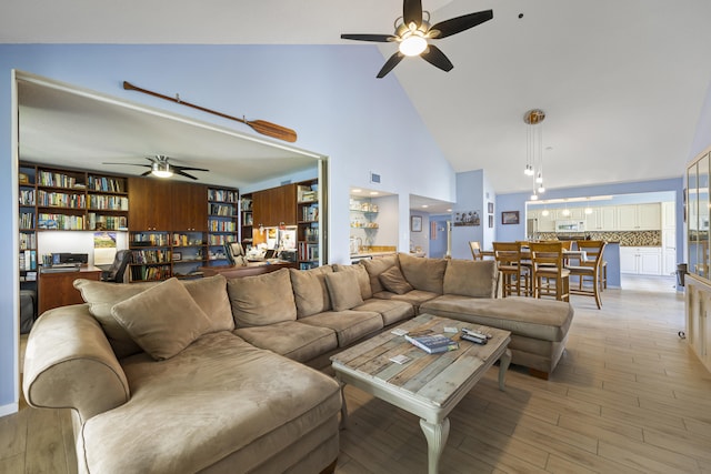 living room with light hardwood / wood-style floors and high vaulted ceiling