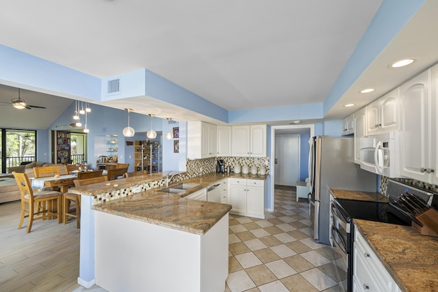 kitchen with kitchen peninsula, stainless steel appliances, white cabinetry, and sink