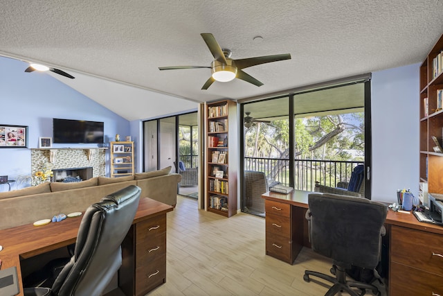 office with a textured ceiling, light wood-type flooring, ceiling fan, and lofted ceiling