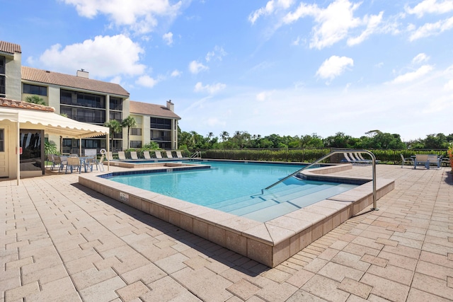 view of swimming pool featuring a patio area and a hot tub