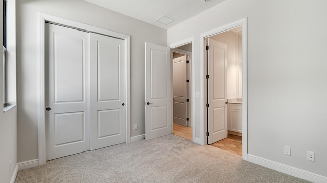 unfurnished bedroom with light colored carpet and a closet