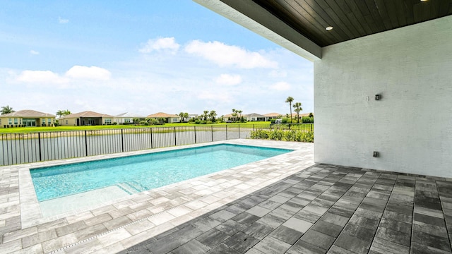 view of swimming pool with a water view and a patio