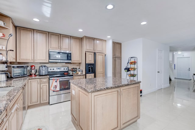 kitchen featuring a kitchen island, appliances with stainless steel finishes, light stone counters, and light tile patterned floors