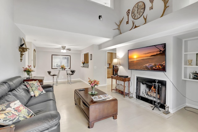 living room featuring built in features and ceiling fan