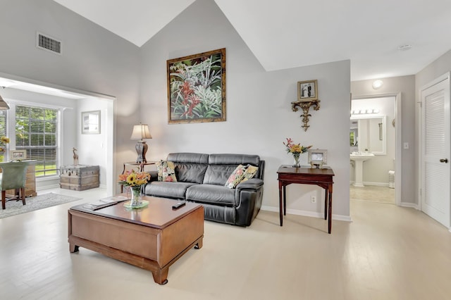 living room with high vaulted ceiling and light hardwood / wood-style flooring