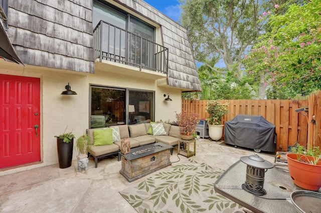 view of patio with an outdoor living space with a fire pit, area for grilling, and a balcony