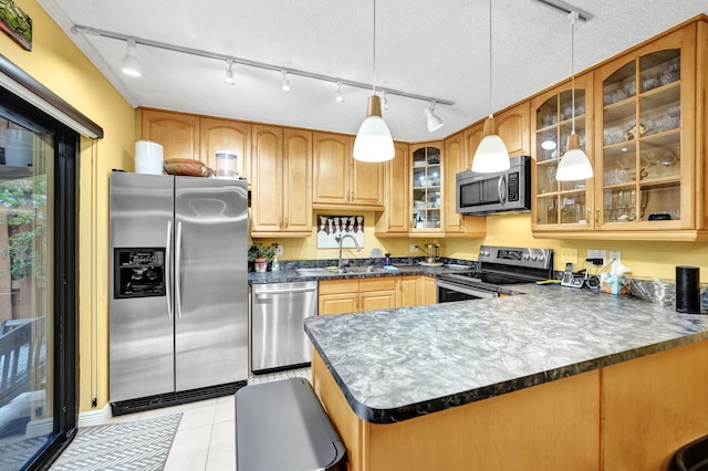 kitchen featuring kitchen peninsula, appliances with stainless steel finishes, light tile patterned flooring, pendant lighting, and sink