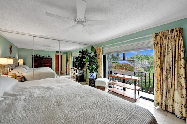 tiled bedroom featuring a textured ceiling, ceiling fan, a closet, and access to outside