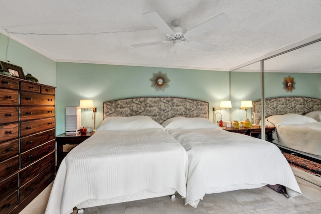 bedroom with ceiling fan, a closet, a textured ceiling, and ornamental molding