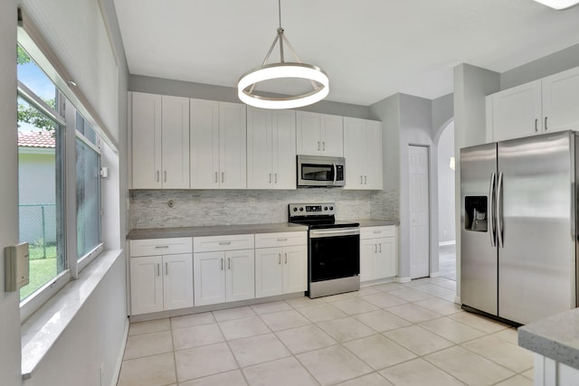 kitchen with pendant lighting, white cabinets, and stainless steel appliances