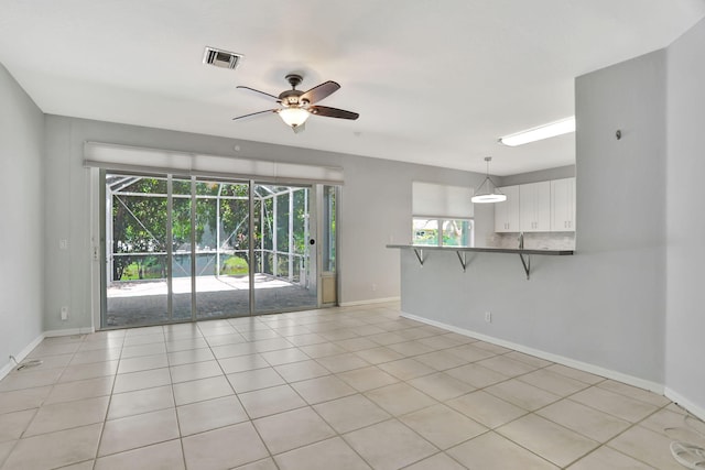 tiled spare room with ceiling fan