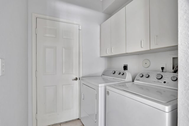 washroom with washer and dryer, cabinets, and light tile patterned floors