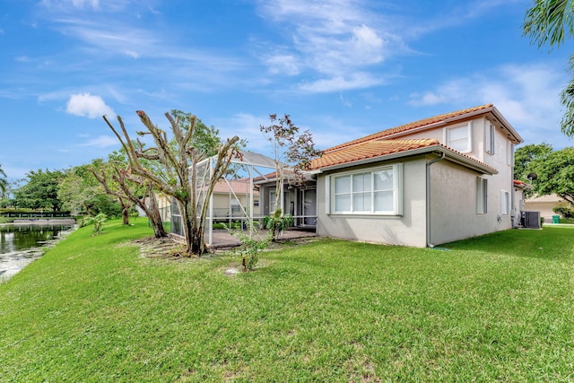 exterior space featuring a water view, central air condition unit, a lawn, and glass enclosure