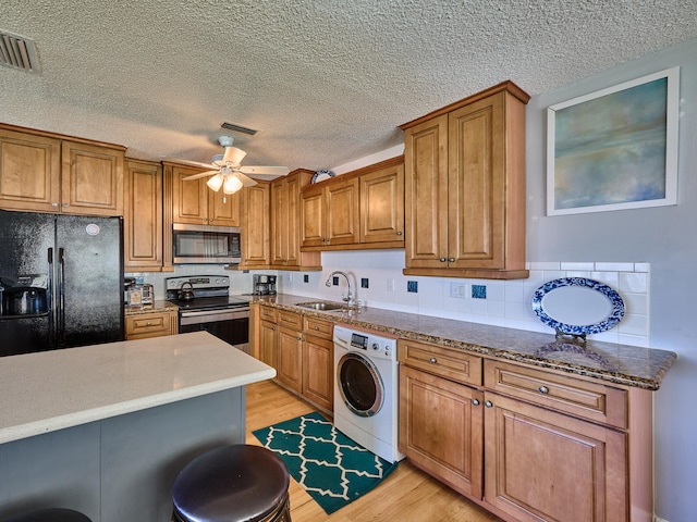 kitchen with washer / clothes dryer, ceiling fan, light hardwood / wood-style floors, appliances with stainless steel finishes, and sink