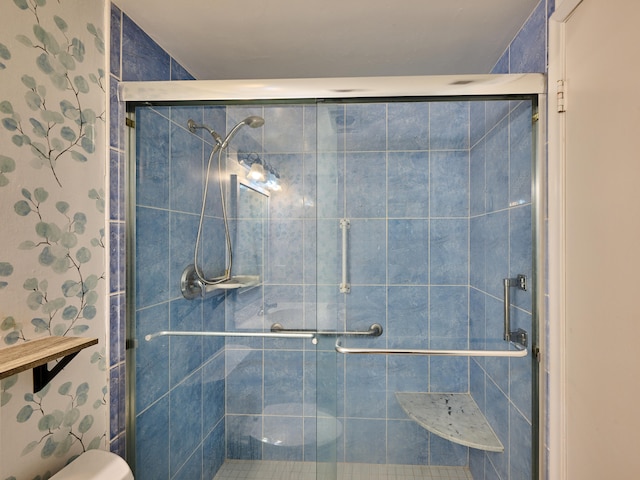 bathroom with toilet and a shower with door