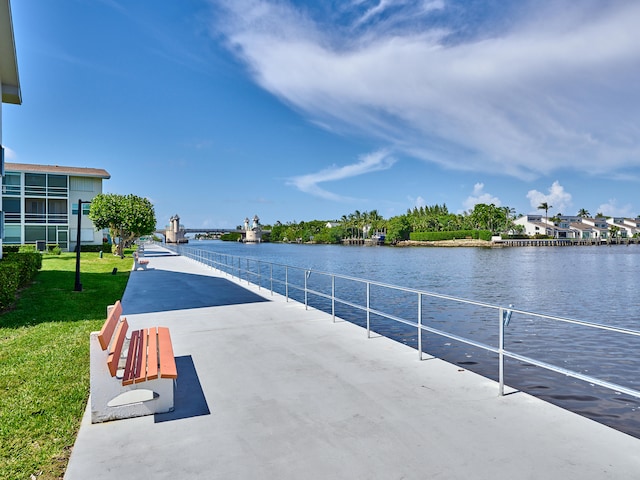 view of dock featuring a water view and a lawn