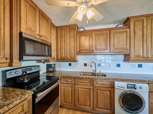 kitchen featuring appliances with stainless steel finishes, sink, washer / clothes dryer, a textured ceiling, and ceiling fan