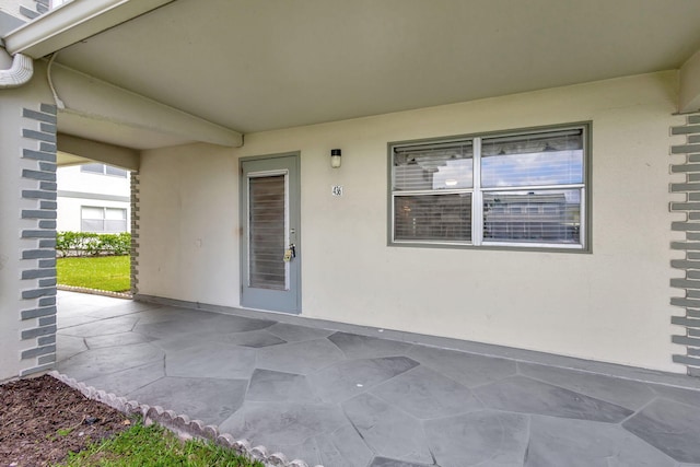 view of exterior entry with a patio