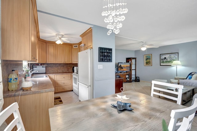 dining area featuring sink, ceiling fan with notable chandelier, and light tile patterned floors