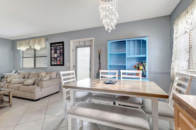 tiled dining area featuring a chandelier